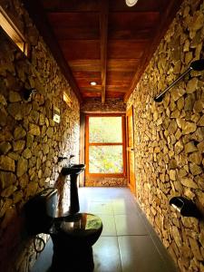Habitación de piedra con ventana y pared de piedra. en Atarisi Lodge, en Rurrenabaque