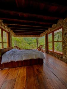 ein Schlafzimmer mit einem Bett in einem Zimmer mit Fenstern in der Unterkunft Atarisi Lodge in Rurrenabaque