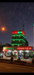 ein Gebäude mit Neonschildern darüber in der Unterkunft Nhà nghỉ Bình Yên in Pleiku