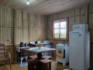 a kitchen with a refrigerator and a table in it at Recanto do Cachoeira do Nassuca in Cambará