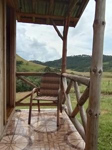 una silla sentada en un porche con vistas en Recanto do Cachoeira do Nassucar en Cambará