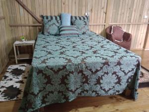 a bedroom with a bed with a blue and white blanket at Recanto do Cachoeira do Nassuca in Cambará