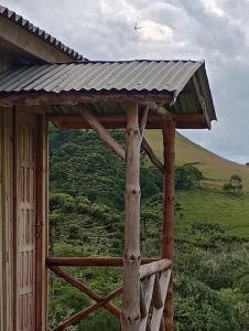 un edificio de madera con techo sobre un campo en Recanto do Cachoeira do Nassucar en Cambará