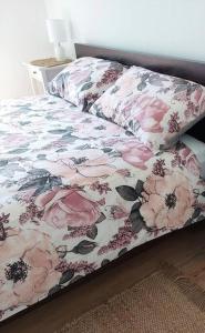 a bed with a floral comforter and two pillows at Lake and Railway Guesthouse in Drysdale