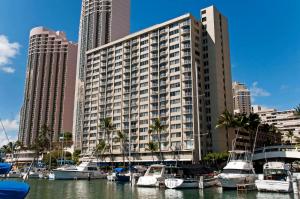 a large building with boats docked in a marina at Ilikai Marina 1BR Condo, Ocean View Haven in Honolulu