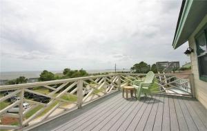 a deck with a table and chairs on a house at Belvedere in Edisto Island +5 photos