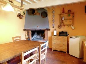una cucina con camino, tavolo e sedie di Belvilla by OYO characteristic Tuscan flat a Lucchio