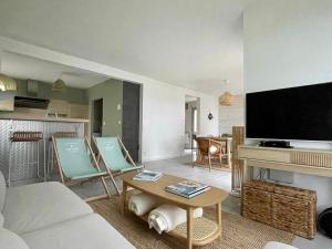 een woonkamer met een bank, een tafel en een tv bij Premium holiday home in top location with sea view, Plougasnou in Plougasnou
