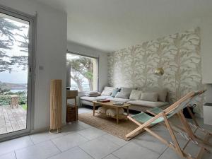 een woonkamer met een bank en een tafel bij Premium holiday home in top location with sea view, Plougasnou in Plougasnou