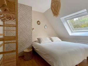een slaapkamer met een bed, een ladder en een raam bij Premium holiday home in top location with sea view, Plougasnou in Plougasnou