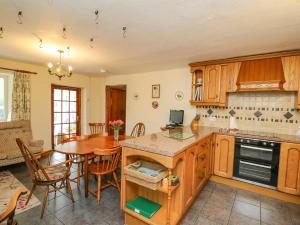 a kitchen with a table and a dining room at Tanyrallt Farm in Beulah