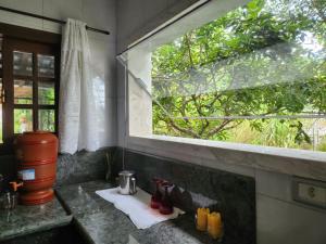 encimera de cocina con ventana y fregadero en Pousada mais confortável de Itapema, en Itapema