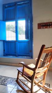 a rocking chair in a room with a blue door at La Casa del Café in Campeche