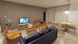 a living room with a couch and a dining room at Cobertura Com Vista Para a Praia in São Vicente