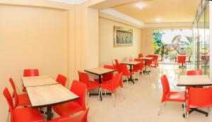 un comedor con mesas y sillas rojas en Hotel Savilayo, en Ica