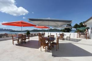 a patio with tables and chairs and umbrellas at Haven 1916 Pension House in Coron