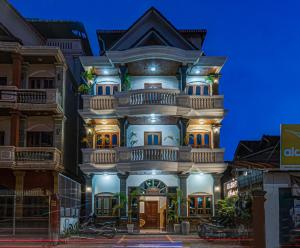 a large white house with a blue sky at Archaic House- Siem Reap in Siem Reap