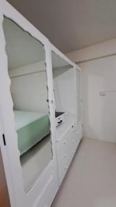 un armario blanco con estanterías y una almohada verde en Mead Road Homestay Tours &Transfers Deluxe Flat 1 Bedroom en Suva