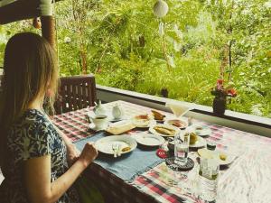 a woman sitting at a table with a plate of food at Sigiri Saman Home Stay in Sigiriya