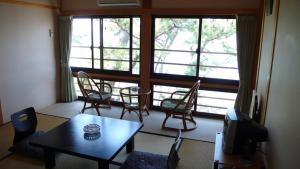 a living room with a table and chairs and a window at Nisshokan in Ise