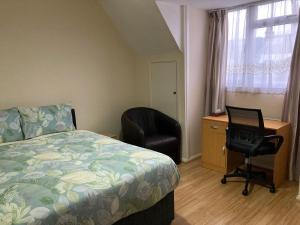 Schlafzimmer mit einem Bett, einem Schreibtisch und einem Stuhl in der Unterkunft Eltar Hostle in London