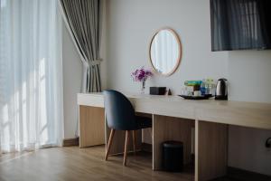 ニャチャンにあるMoonlight Nha Trang Hotelのデスク(青い椅子、鏡付)