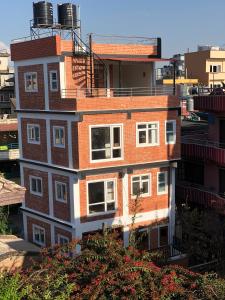 a brick building with white windows on top of it at Your home in Kathmandu! in Kathmandu