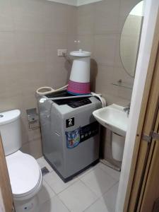 a small bathroom with a toilet and a sink at Shore Residences in Manila