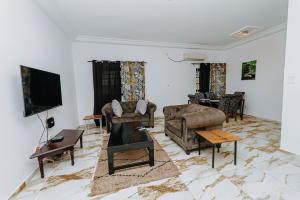 a living room with couches and a flat screen tv at Sublim'Apparts Léo 2000 - Lomé in Lomé