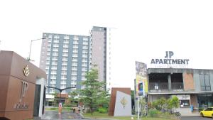 a city with a tall apartment building in the background at Sienna Residence Bogor in Kedungbadak