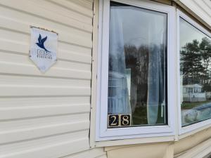 Una ventana en una casa con un cartel. en BLUE BIRD HOLIDAY HOME en Durham