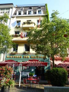 ein Restaurant mit Tischen und Stühlen vor einem Gebäude in der Unterkunft Hotel Rebstock in Luzern