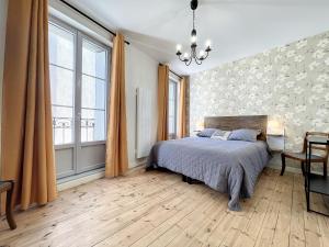 una camera da letto con un letto e una grande finestra di Gîte confortable à Saugues pour randonneurs, 3 chambres spacieuses avec salle d'eau privative - FR-1-582-365 a Cubelles