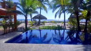 a view of the beach from the pool at Bungalows Tree Tops - Adults Only in Zihuatanejo