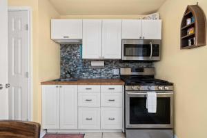 een keuken met witte kasten, een fornuis en een magnetron bij Rockport Redfish Cottage in Rockport