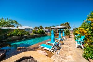een zwembad met ligstoelen en parasols bij Rockport Redfish Cottage in Rockport