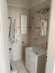 a bathroom with a sink and a mirror and towels at Apartamento Céntrico, Moderno y Tranquilo in Caleta Olivia