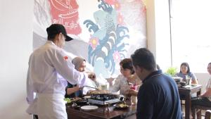 a man serving food to a group of people at Sienna Hotel Bogor in Kedungbadak