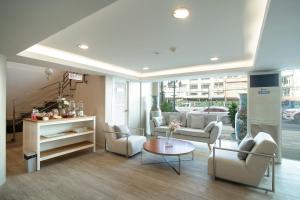 a living room with couches and chairs and a table at Bangkok Loft Inn in Bangkok