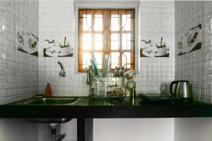 a kitchen counter with a sink and a window at Jolene's Ashvem in Mandrem