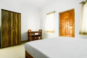 - une chambre avec un lit et une porte en bois dans l'établissement Jolene's Ashvem, à Mandrem