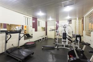 a gym with several treadmills and machines in a room at Hotel Lopes Caxambu in Caxambu