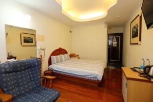 1 dormitorio con 1 cama y 1 sofá azul en Yushan House B&B, en Xinyi
