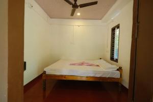 a bed in a room with a ceiling fan at Ethus'villahomestay in Mararikulam