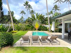 a backyard with a pool and chairs and palm trees at SAWAN Residence Pool Villas in Lamai