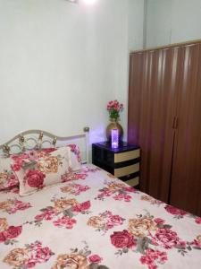 Un dormitorio con una cama con flores rosas. en Acuarela del Rio H#1 Cerca Terminal Terrestre Habitación privada con baño, en Guayaquil