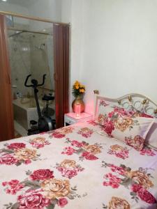 Un dormitorio con una cama con flores. en Acuarela del Rio H#1 Cerca Terminal Terrestre Habitación privada con baño, en Guayaquil