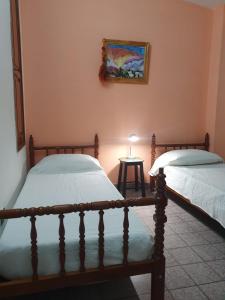 1 dormitorio con 2 camas y mesa con lámpara en Dúplex La Nona en Salta
