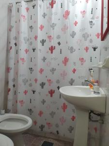 y baño con cortina de ducha, aseo y lavamanos. en Dúplex La Nona en Salta