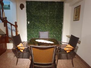 una mesa y sillas en una habitación con una pared verde en Dúplex La Nona en Salta